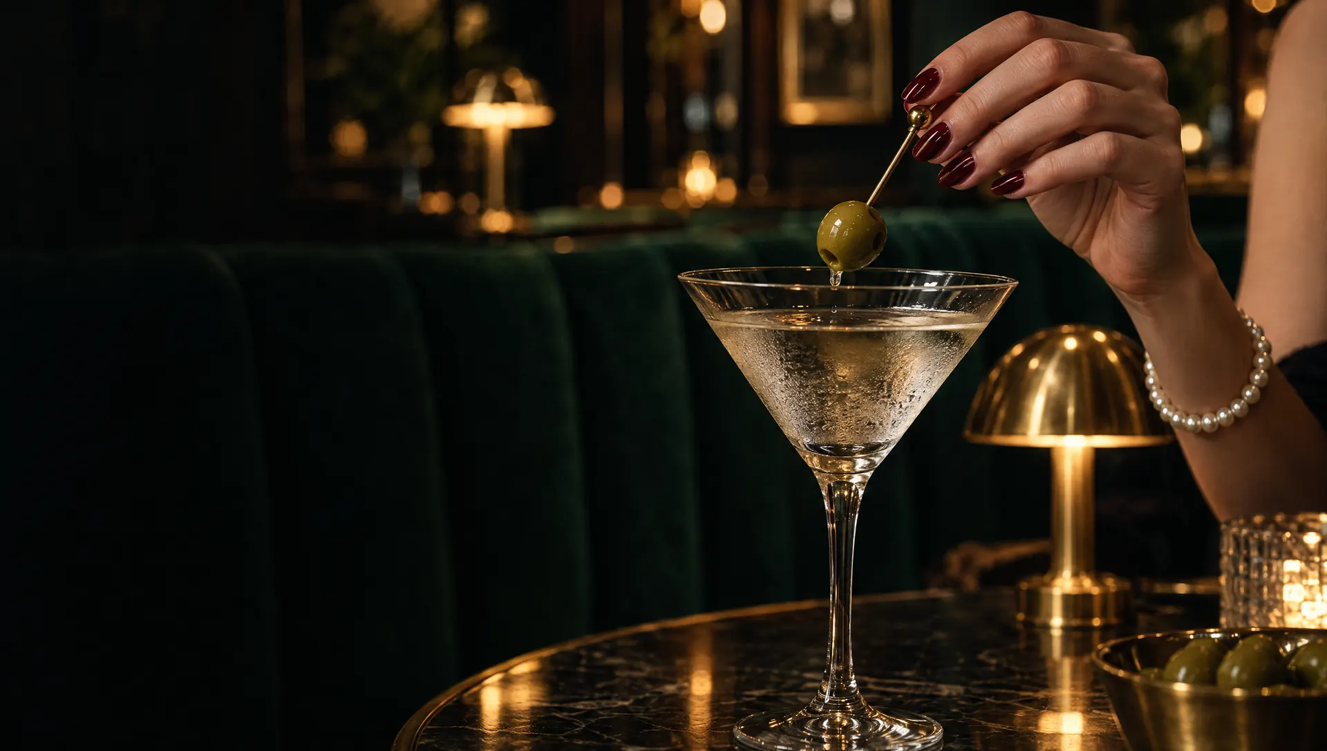 A martini olive lifted from the glass